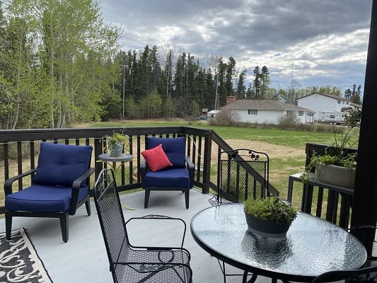 Patio with chairs overlooking a green landscape.