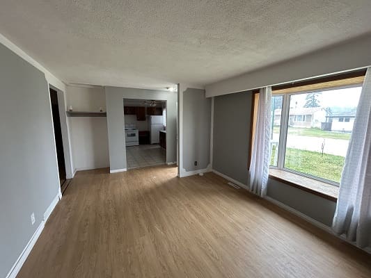 Empty living room with hardwood floors.