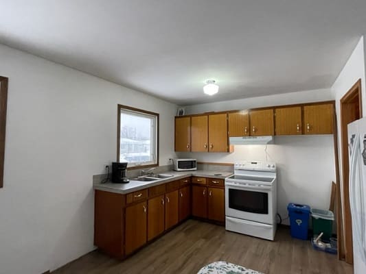 Simple kitchen with wooden cabinets and appliances.