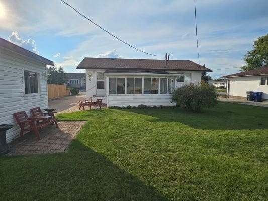 House with green lawn and patio furniture.