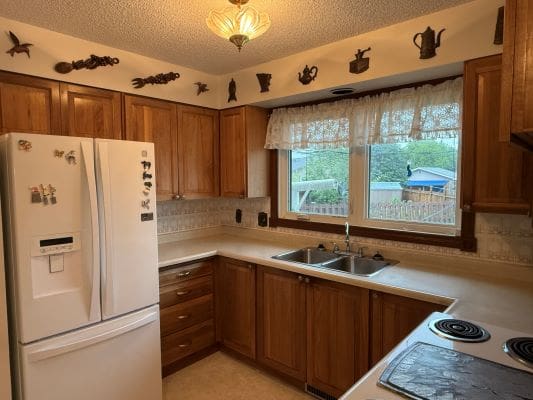 Wooden kitchen with decorative items on shelves.