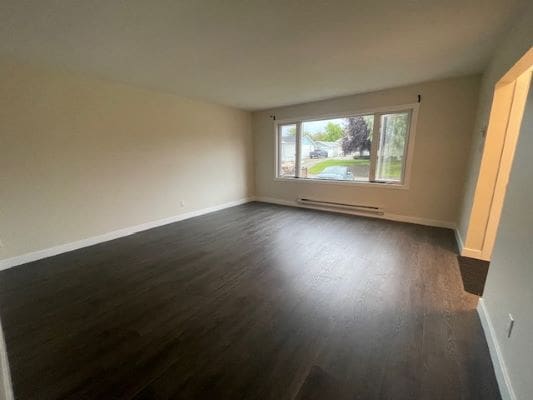 Empty room with dark wood flooring.