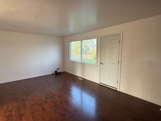 Empty room with wooden floor and window.