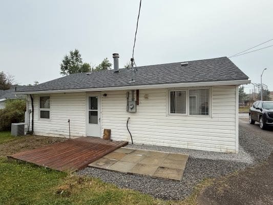 Small white house with gray roof.