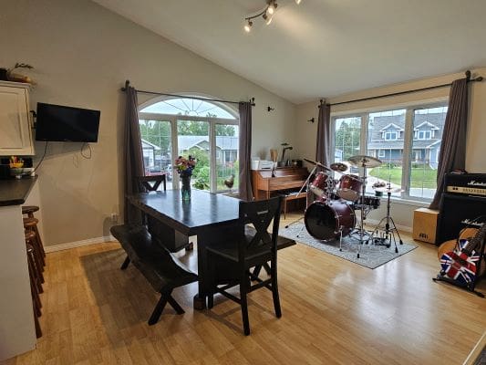 Dining room with drum set and piano.