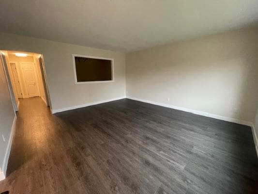 Empty room with dark wood flooring.