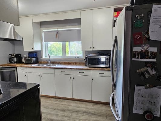 Modern kitchen with white cabinets and appliances.