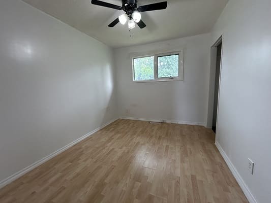 Empty room with wooden floor and window.
