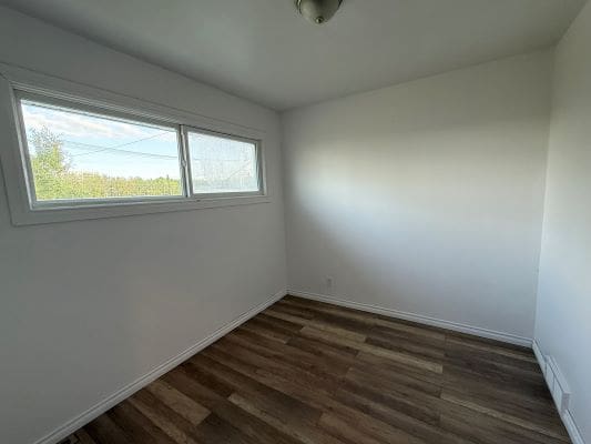 Empty room with wooden floor and window.