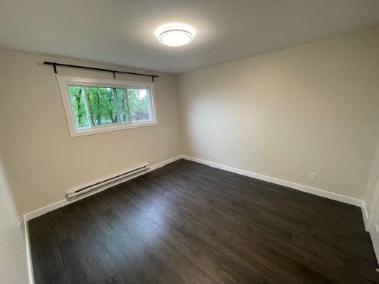 Empty room with hardwood floor and window.