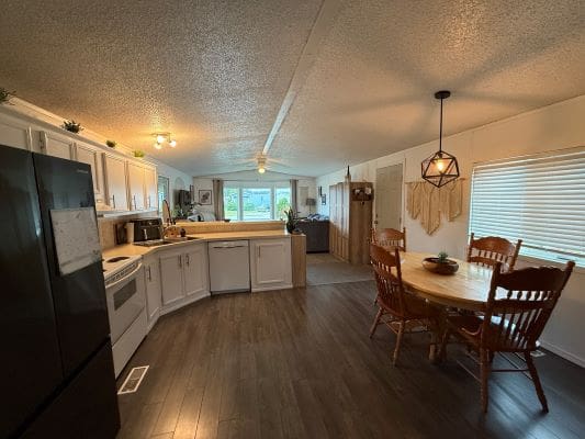 Spacious kitchen with dining area and lighting.