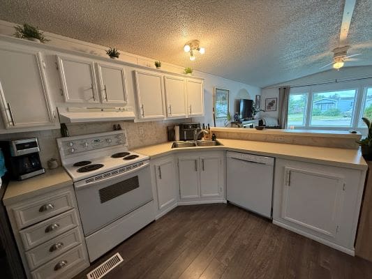 Modern kitchen with white cabinets and appliances.