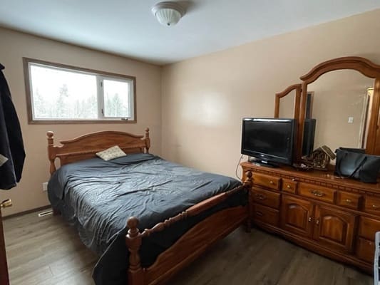 Bedroom with wooden furniture and television.