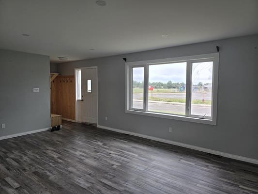 Empty room with large window and door.