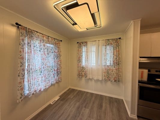 Empty room with floral curtains and light.