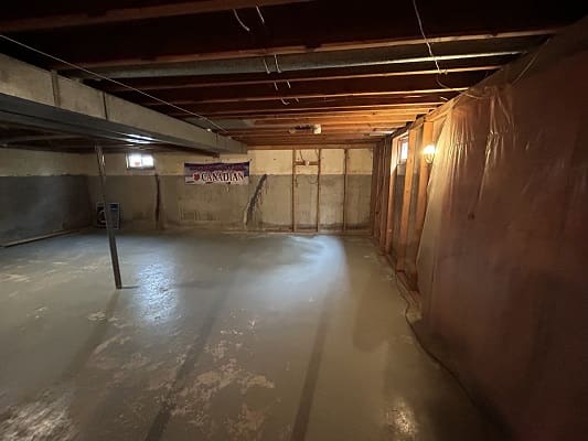 Unfinished basement with exposed beams and walls.
