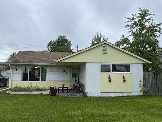 Single-story house with green lawn.