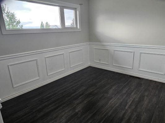 Empty room with dark wooden flooring.