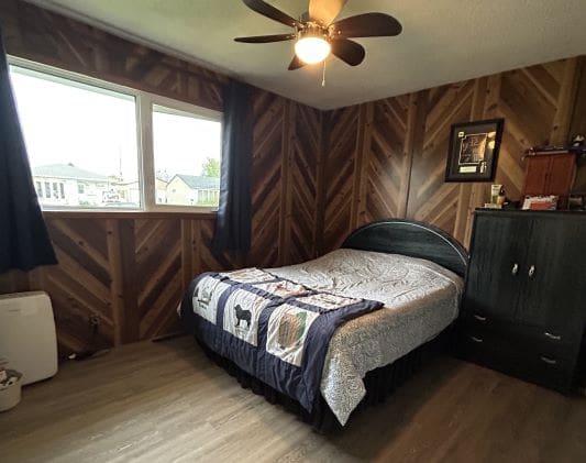 Bedroom with wooden walls and a bed.