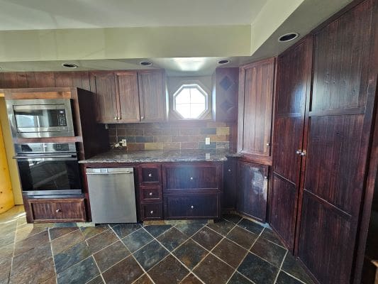 Rustic kitchen with dark wooden cabinets.