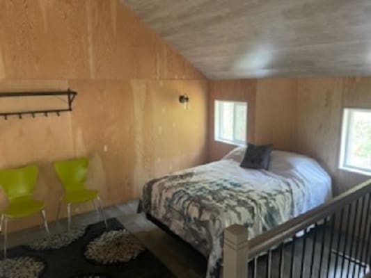 Cozy bedroom with double bed and chairs.