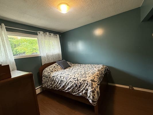 Small bedroom with bed and window view.