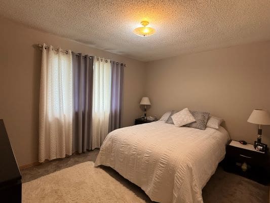Cozy bedroom with double bed and lamps.