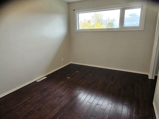 Empty room with dark wooden floor.