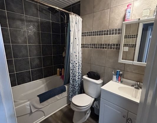 Small bathroom with shower and vanity sink.