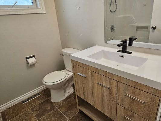 Modern bathroom with sink and toilet.