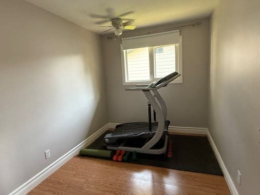Small room with treadmill and exercise equipment.