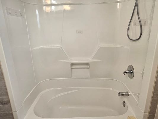 White bathtub with showerhead and faucet.