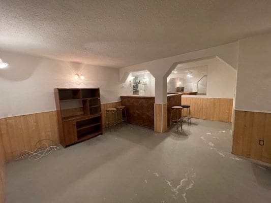 Basement room with wooden furniture and bar.