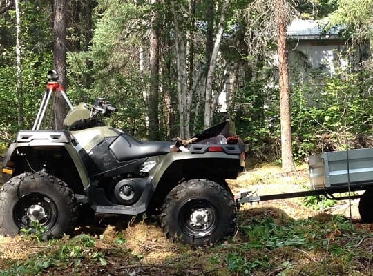 ATV with trailer in forest setting.