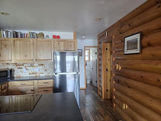 Rustic kitchen with wooden cabinets and fridge.