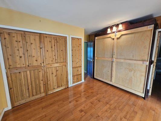 Wooden cabinets in a room with hardwood floor.