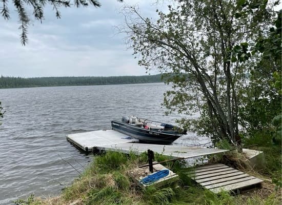 Boat docked on a calm lakeside pier.