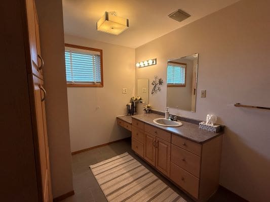 Modern bathroom with wooden cabinets and mirror.