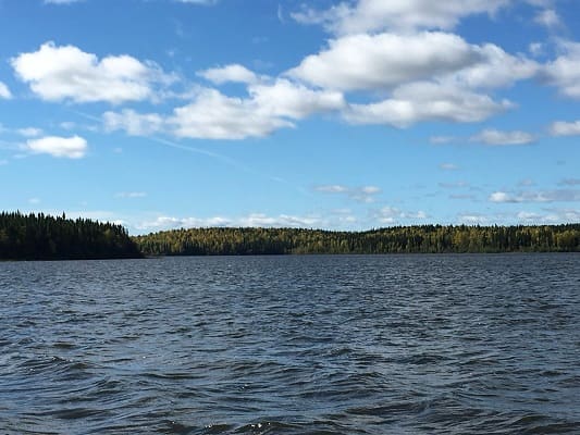 Calm lake under a partly cloudy sky.