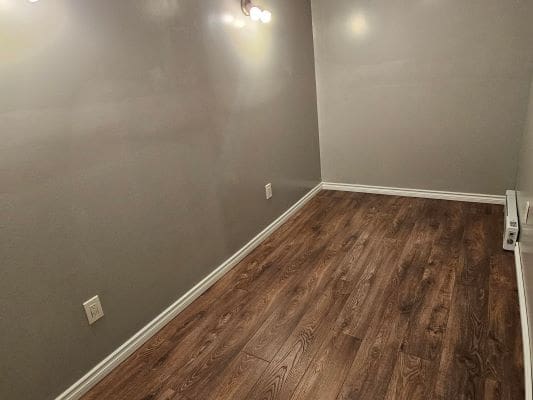 Empty room with wooden floor and lights.