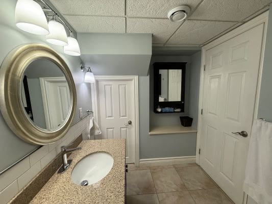 Modern bathroom with round mirror and sink.