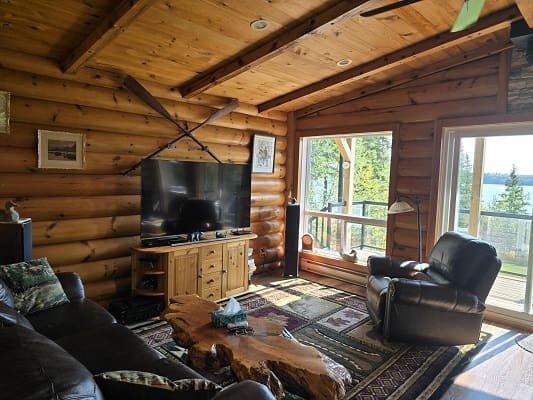 Cozy log cabin living room with TV.