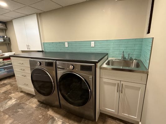 Laundry room with washer, dryer, and sink.