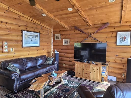 Log cabin living room with leather furniture.