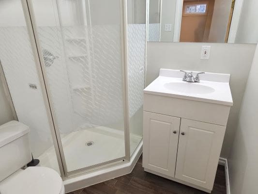 Small bathroom with shower and vanity unit.