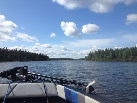 Boat on a lake under cloudy sky.