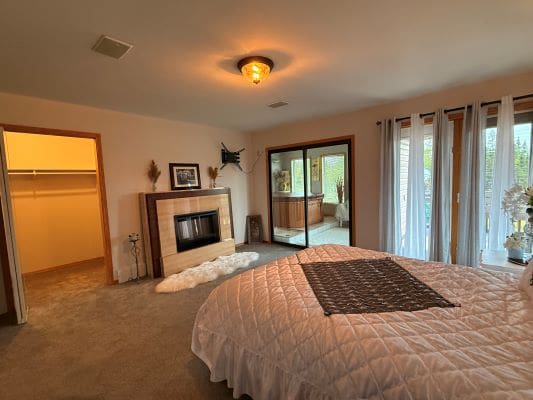 Cozy bedroom with fireplace and sliding doors.