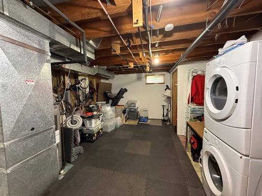 Basement with laundry and exercise equipment.