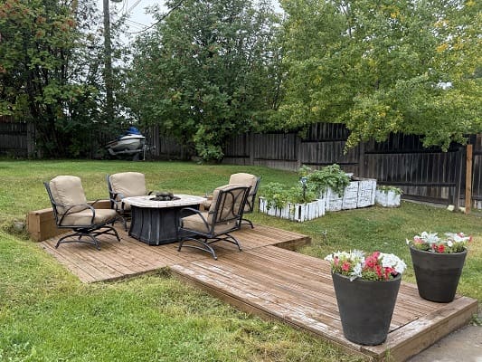 Backyard patio with chairs and fire pit.