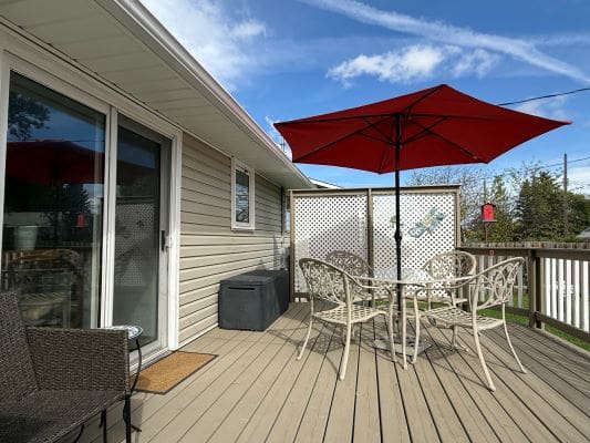 Outdoor patio with red umbrella and furniture.